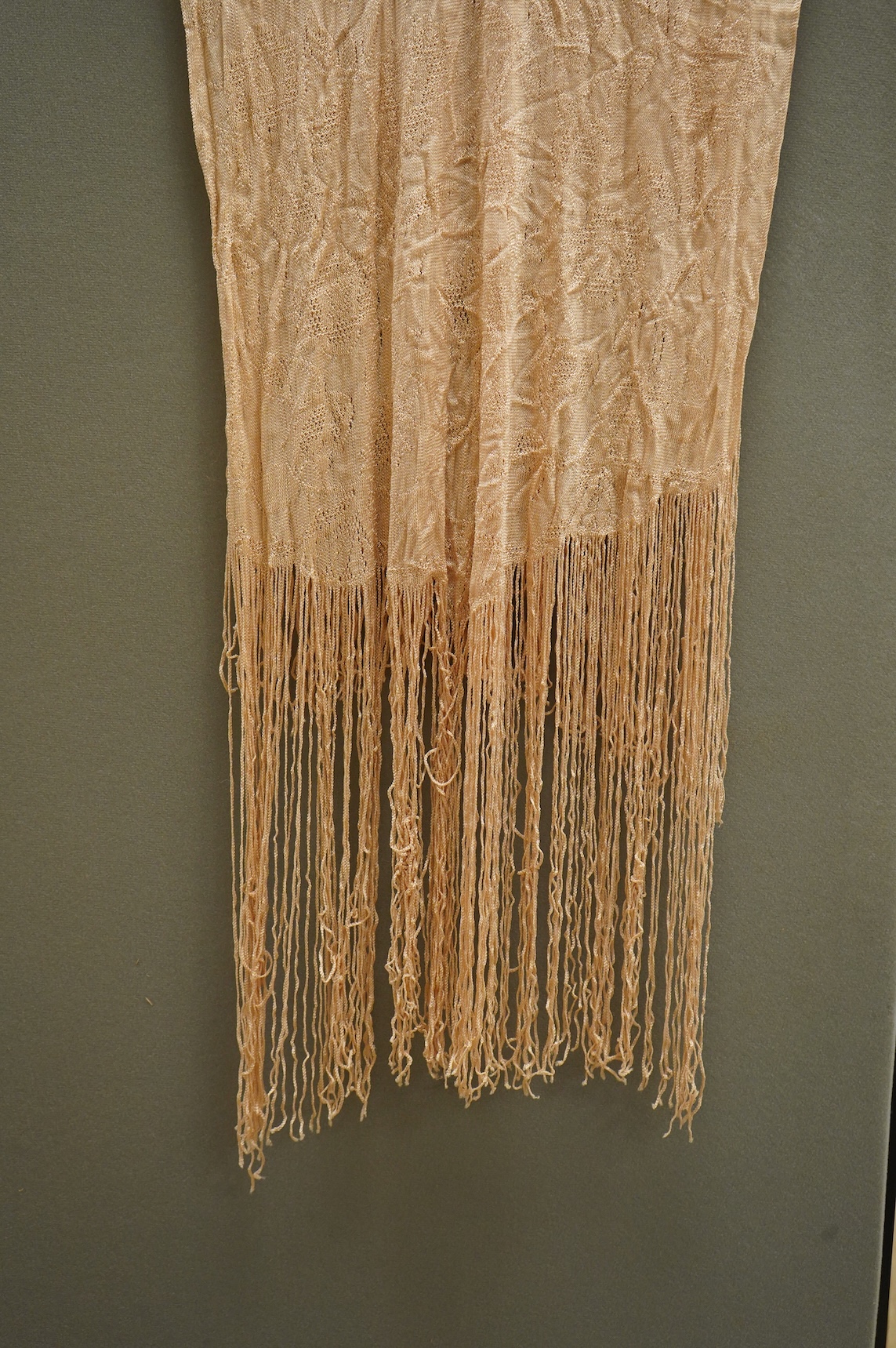 A 1920’s-30’s silk stockinette fringed ladies open sided knitted tabard, sides 56cm long not including fringe. Condition - front point of V slightly worn.